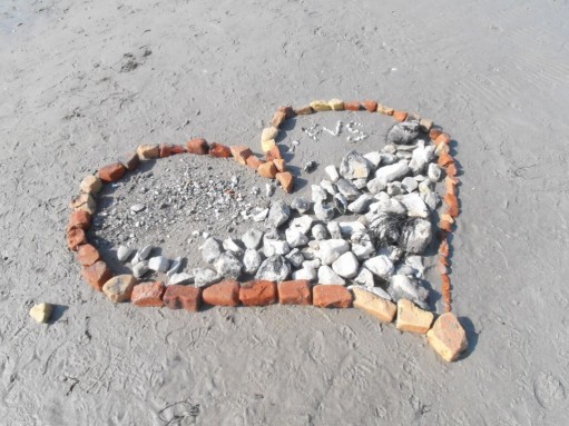 Stenar på strand i form av hjärta.