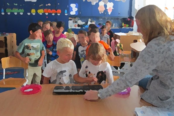 Barn tränar på att trycka på tangentbord som pedagog håller fram.