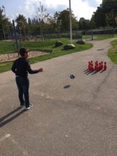 Barn spelar bowling utomhus.