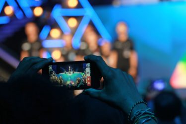 En mobil tar en bild på en grupp människor som är blurrade.