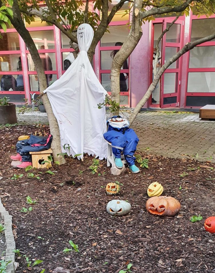 Halloween-pynt på Lindängeskolans atriumgård: ett spöke av lakan och pumpor med ögon och mun.