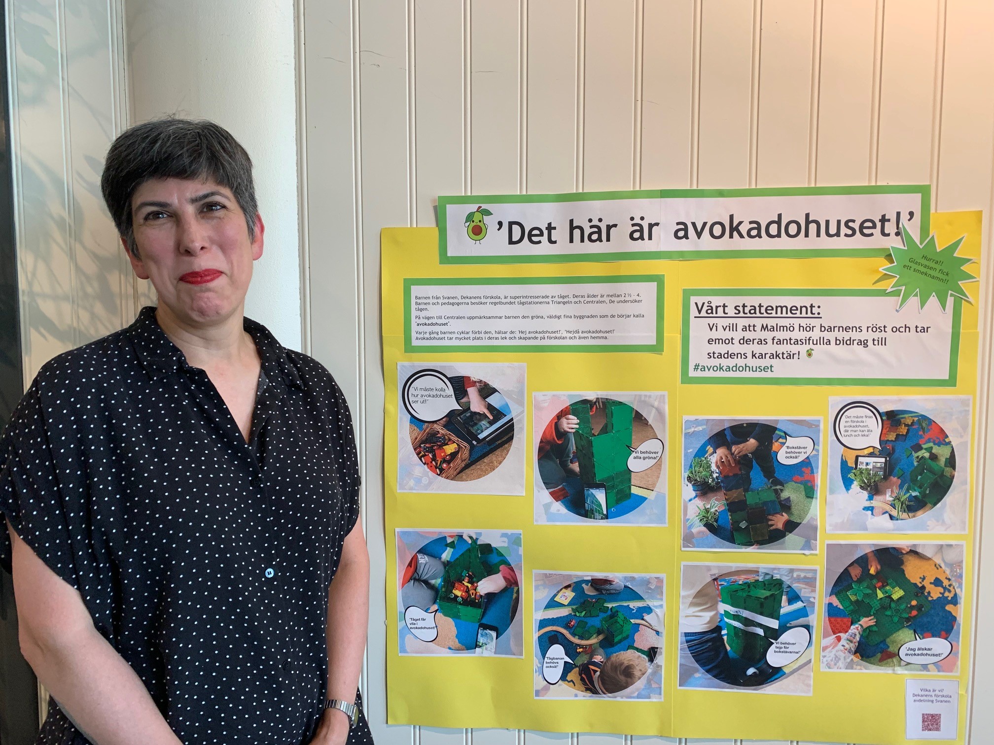 Dilek står framför en poster med information om arbetet med avokadohuset.