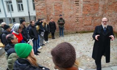 Pedagog föreläser för elever utomhus.