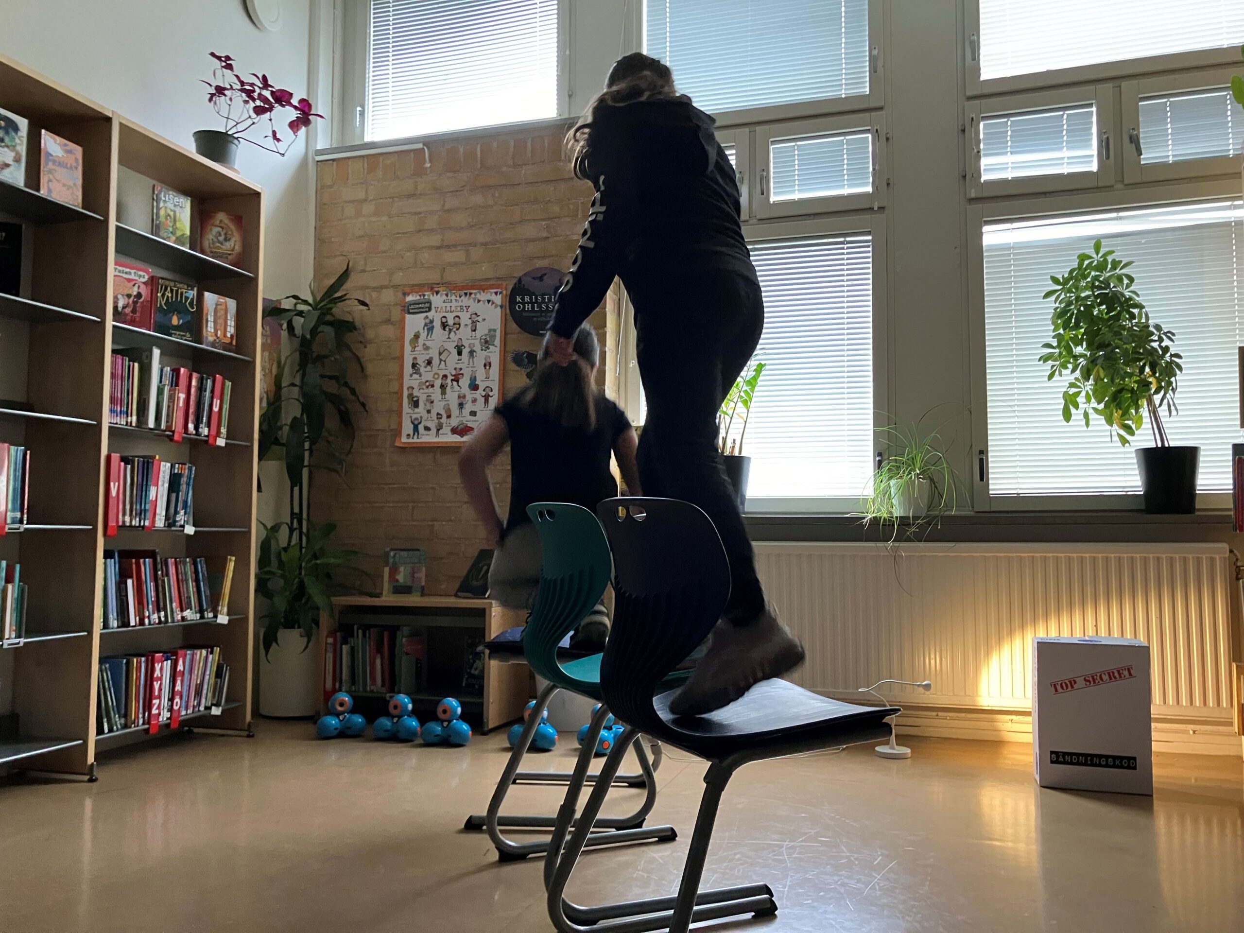 Elever går på några stolar.