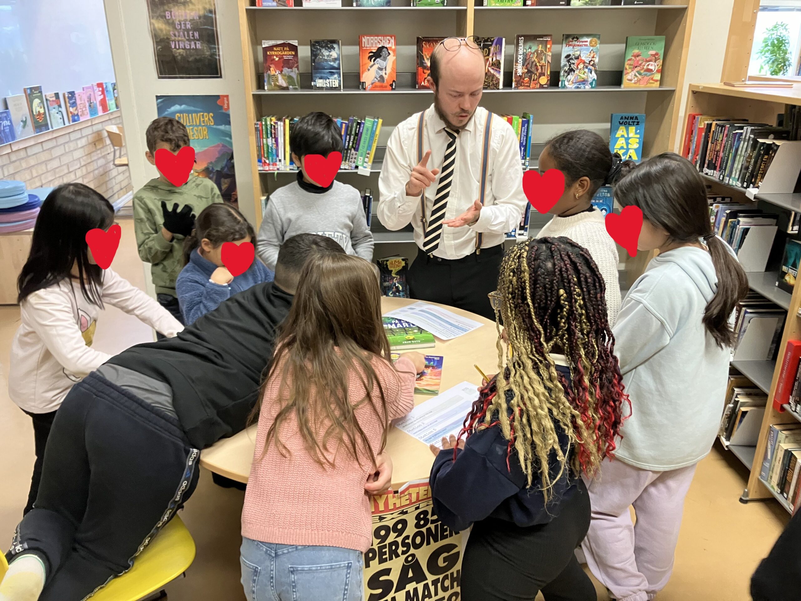 En bibliotekarie pratar med barn i ett skolbibliotek.