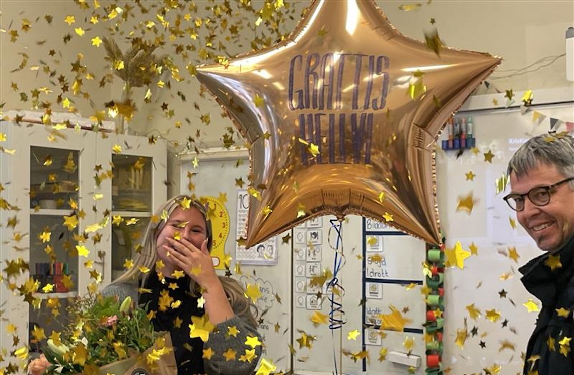 Hellvi Toresson i ett regn av konfetti. På en guldfärgad ballong står det 'Grattis Hellvi'.