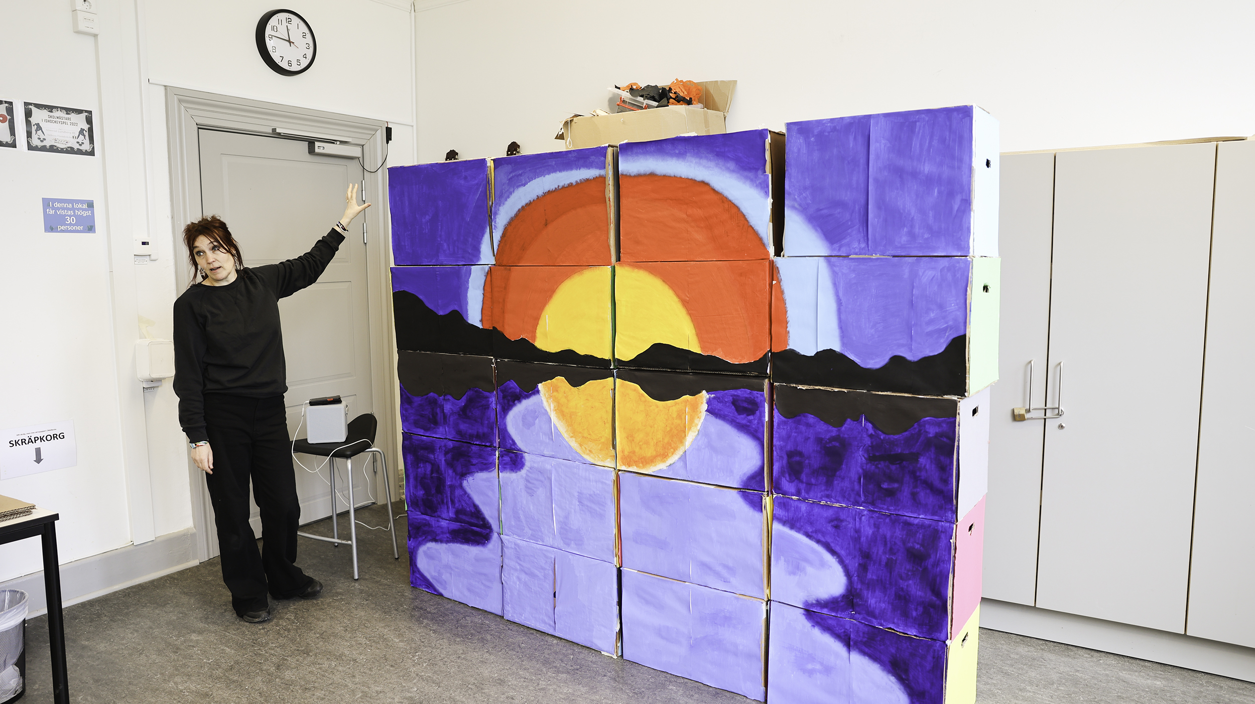 Kartonger staplade på varandra, målade som en solnedgång.