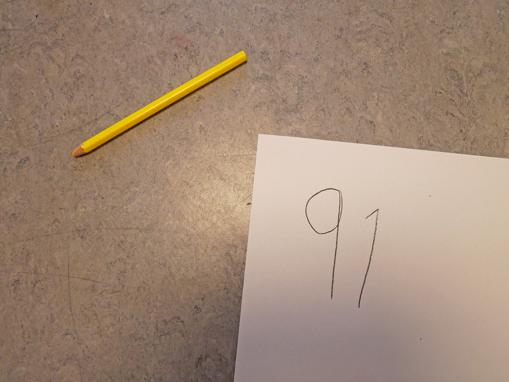 Ett barn har skrivit 91 på ett pappersark.