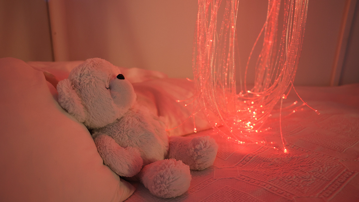 en nallebjörn på en vattensäng med ljusslingor.