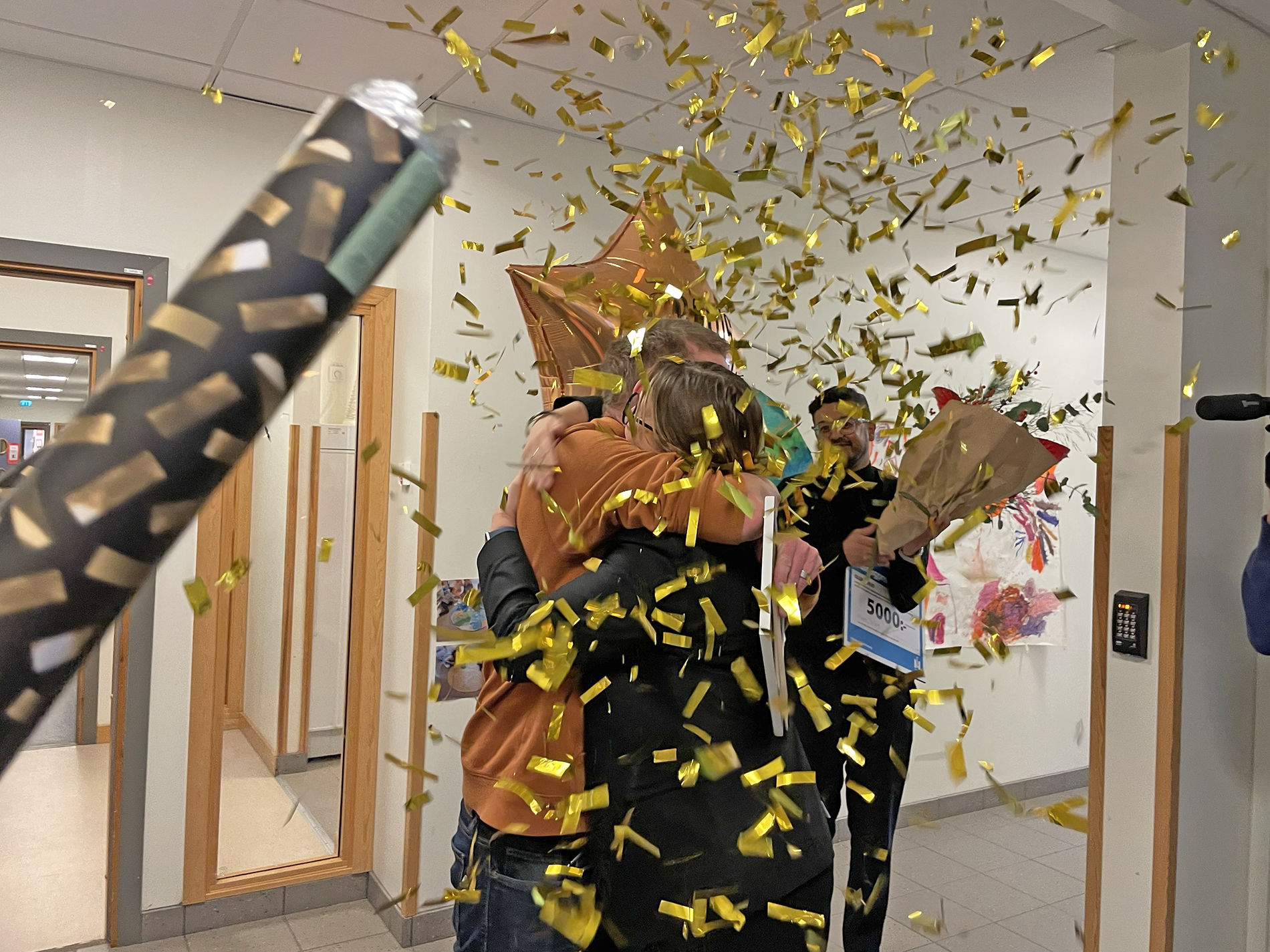 Pristagaren får en kram samtidigt som en konfettikanon avfyras.