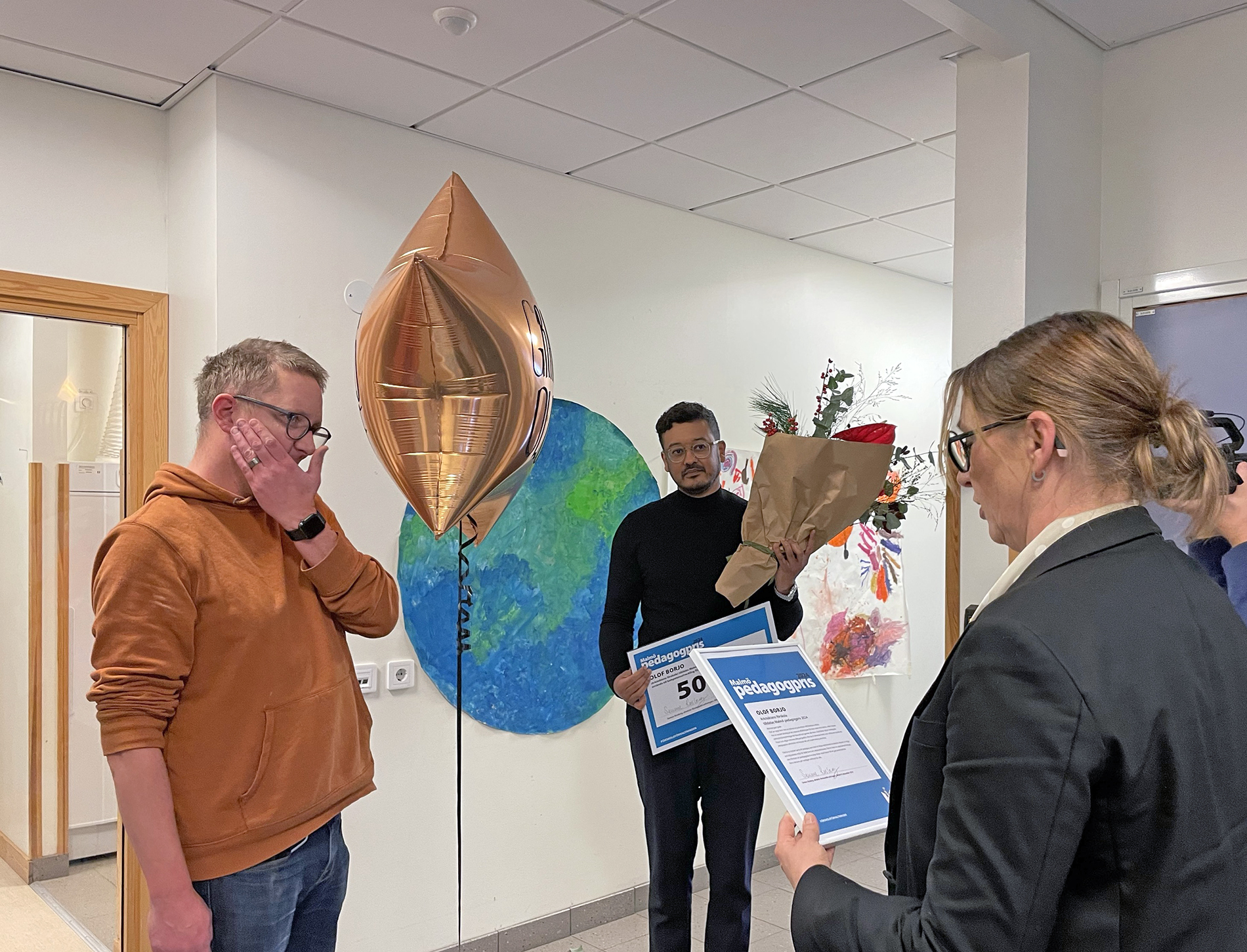 En rörd pristagare lyssnar på motiveringen till varför han tilldelas priset.