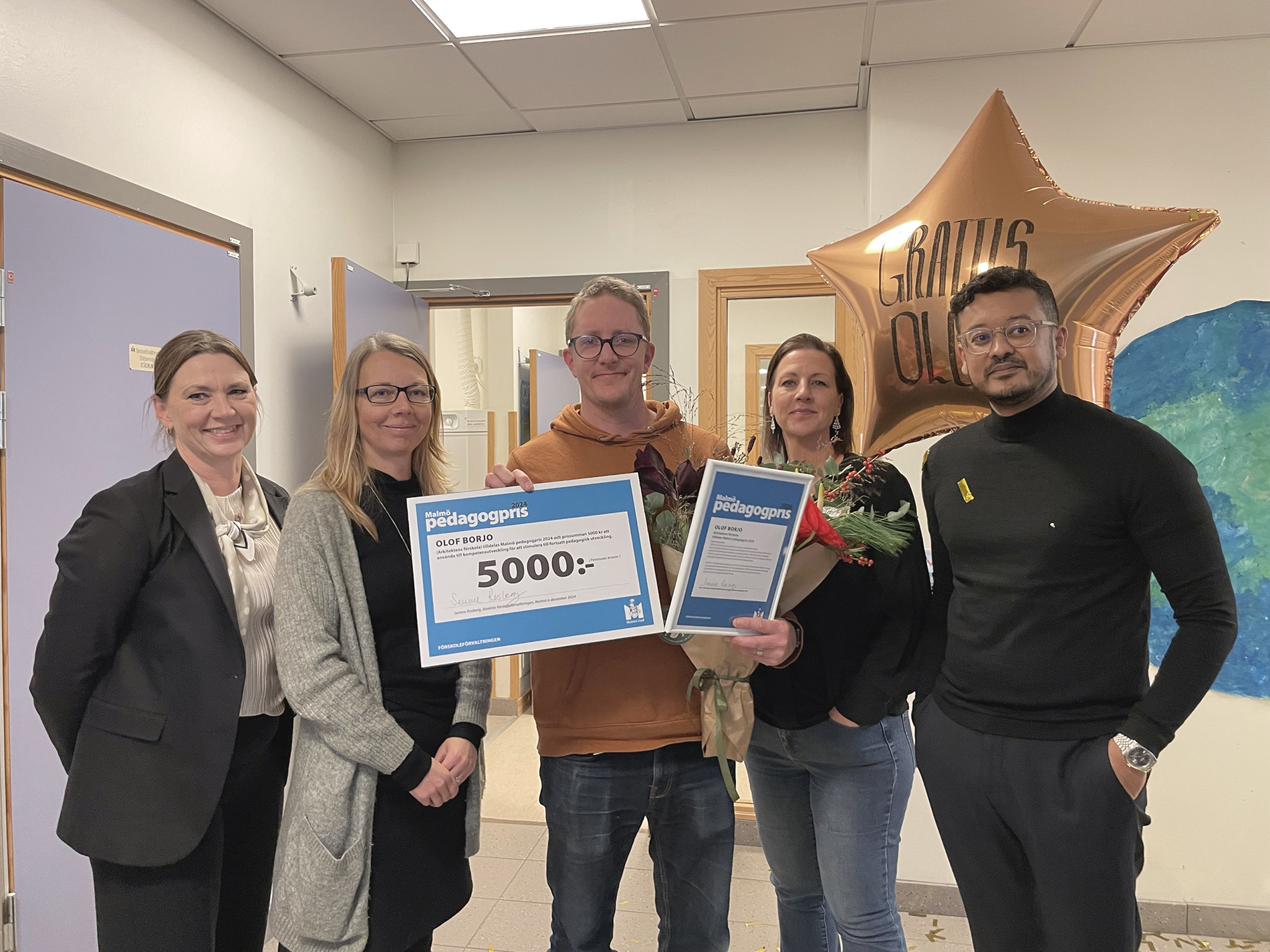 En stolt pristagare poserar med prischecken.