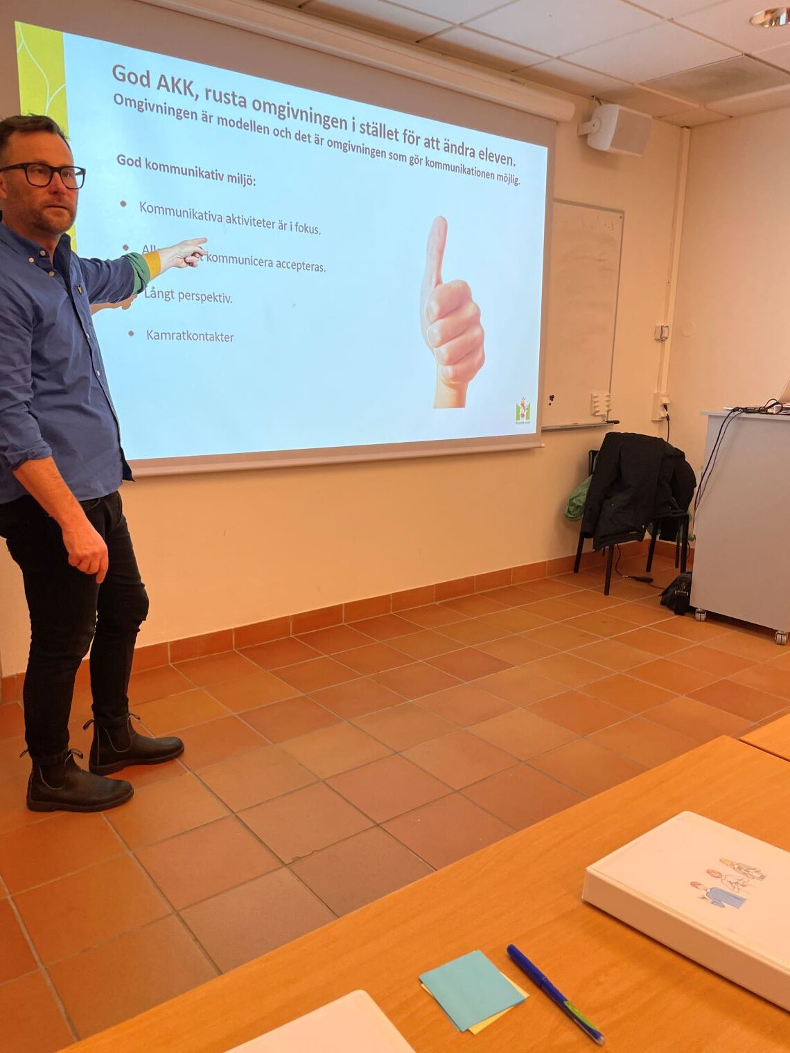 En man står och pekar på en projicerad presentation.