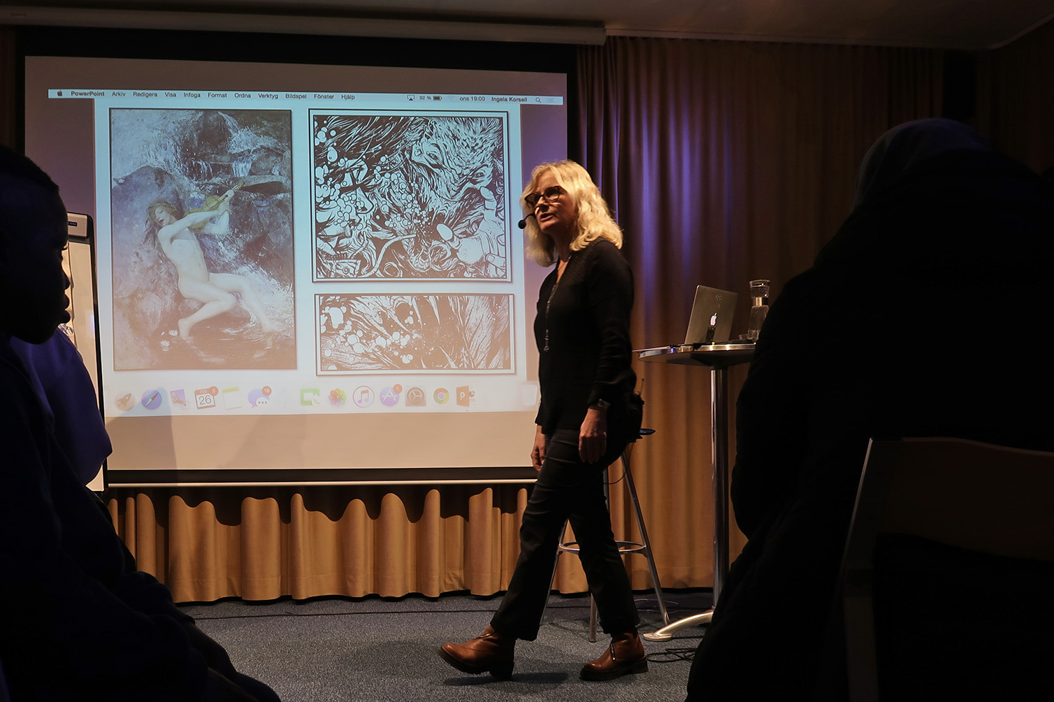 Ingela Korsell föreläser framför projicerade konstverk.