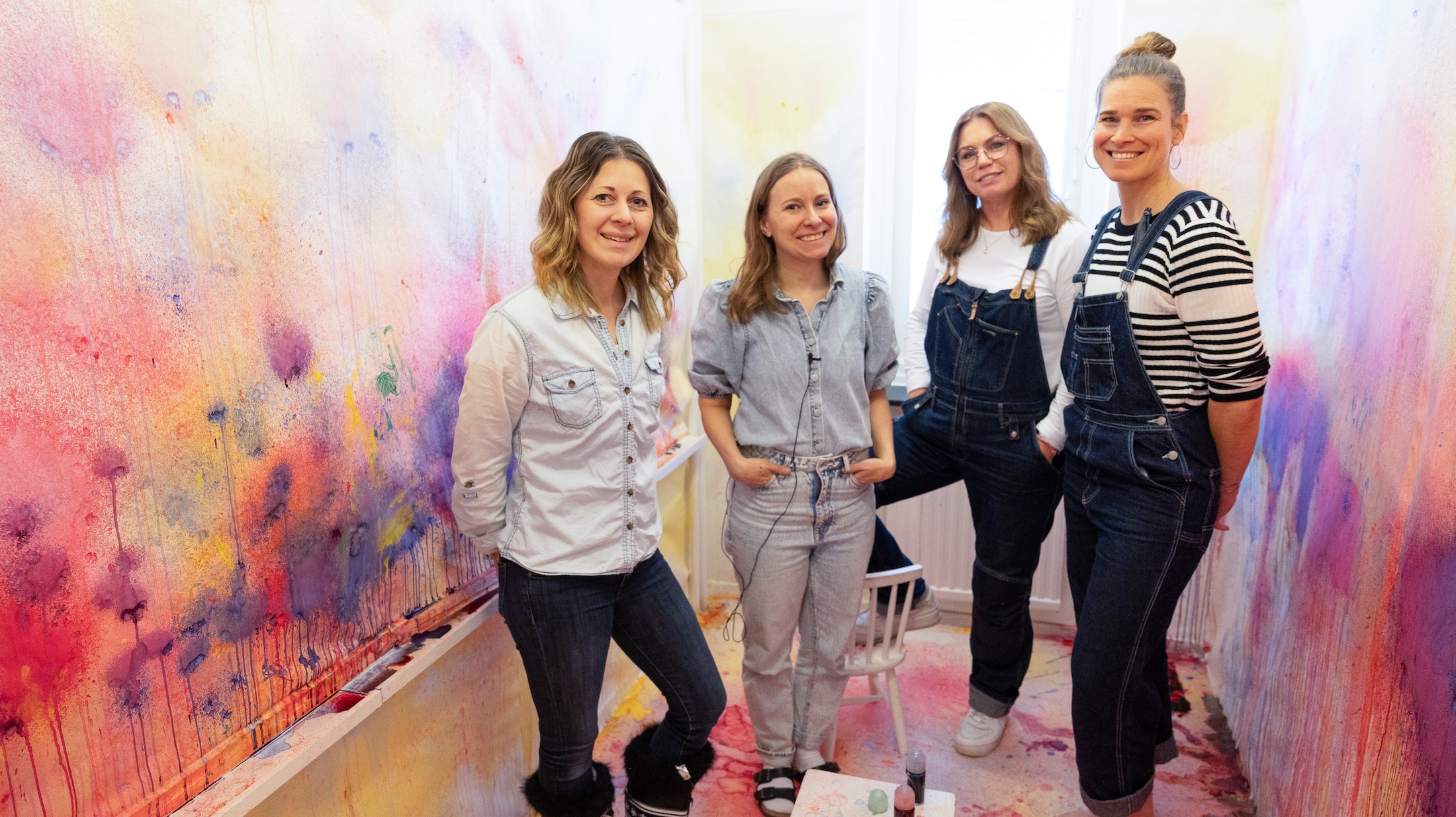 Fyra förste förskollärare står i en ateljé där väggarna sprejats i färgglada kulörer.