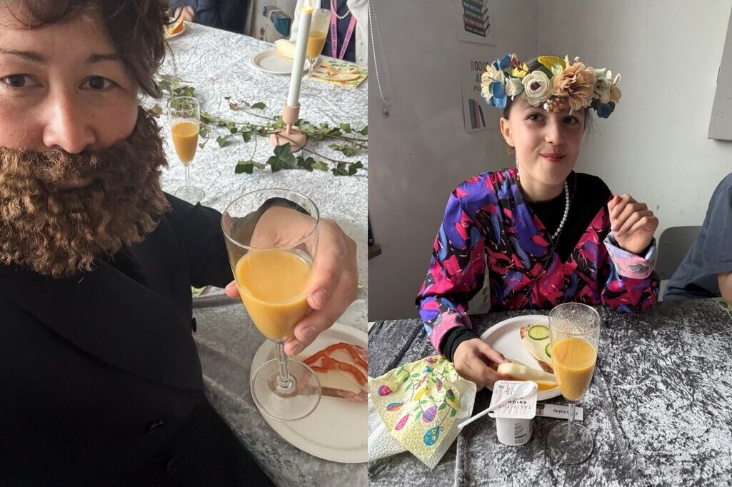 Två personer som klätt ut sig skålar i apelsinjuice.