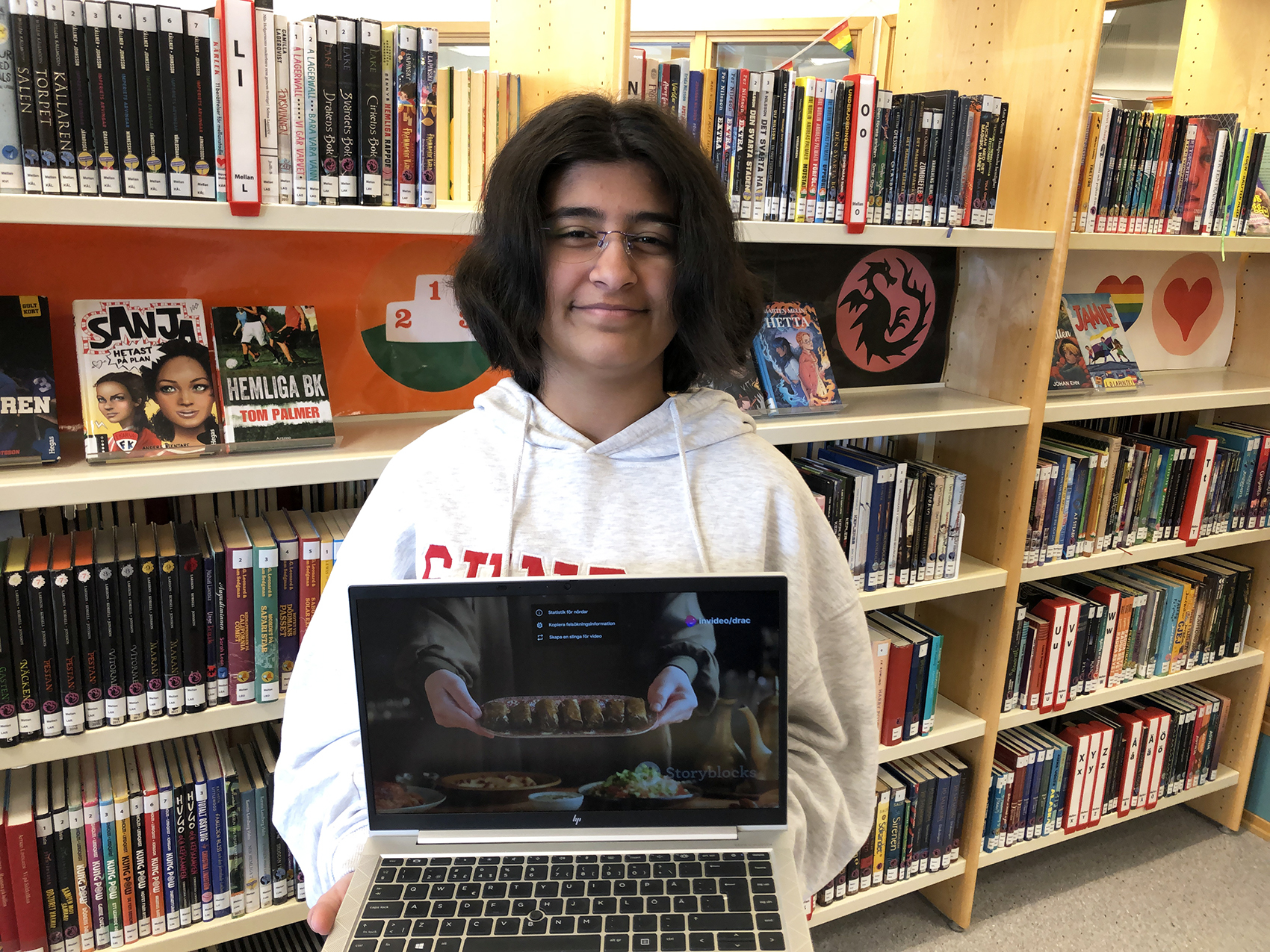 En elev visar upp en film på en laptop.