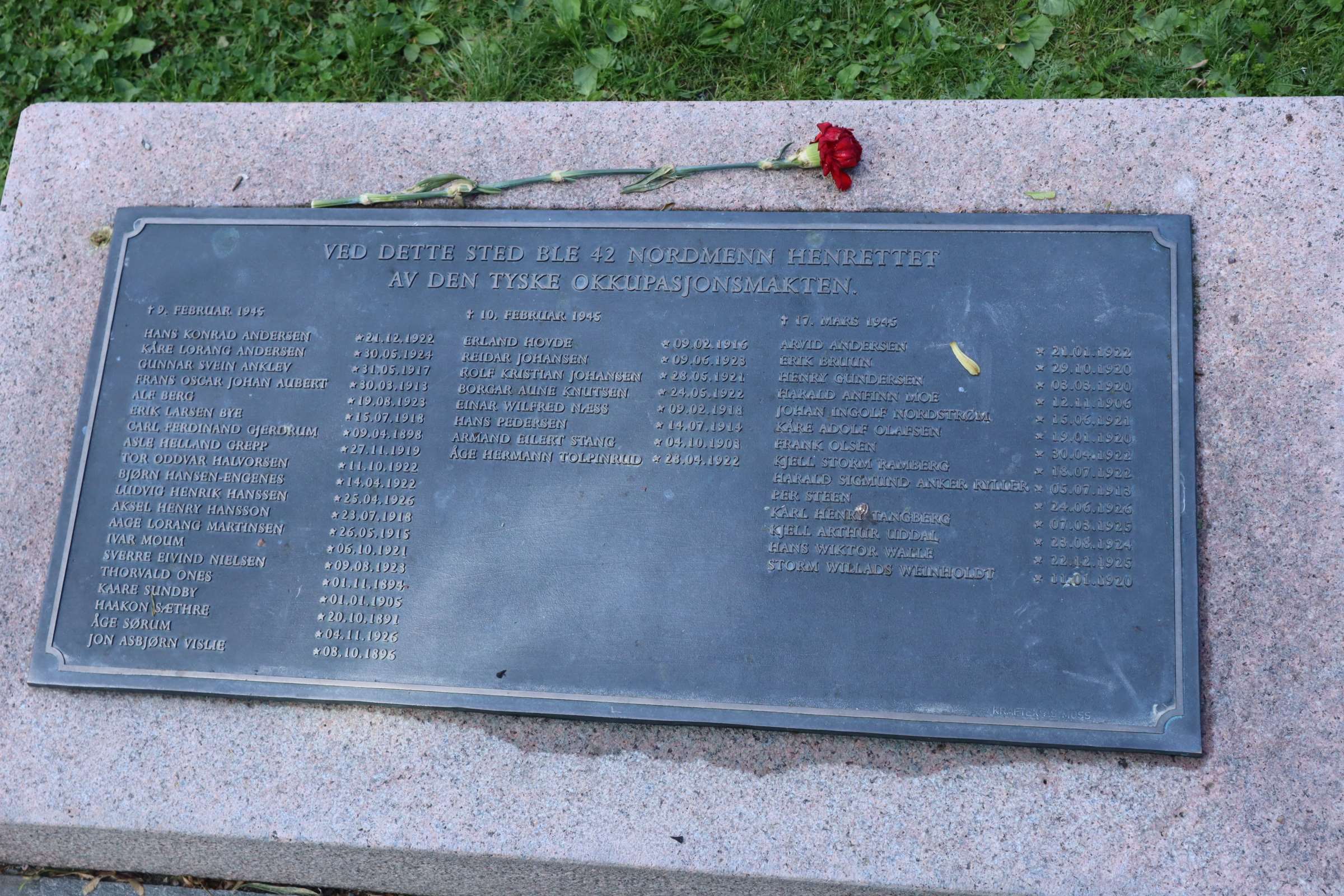 Minnesplaket där någon lagt en ros.