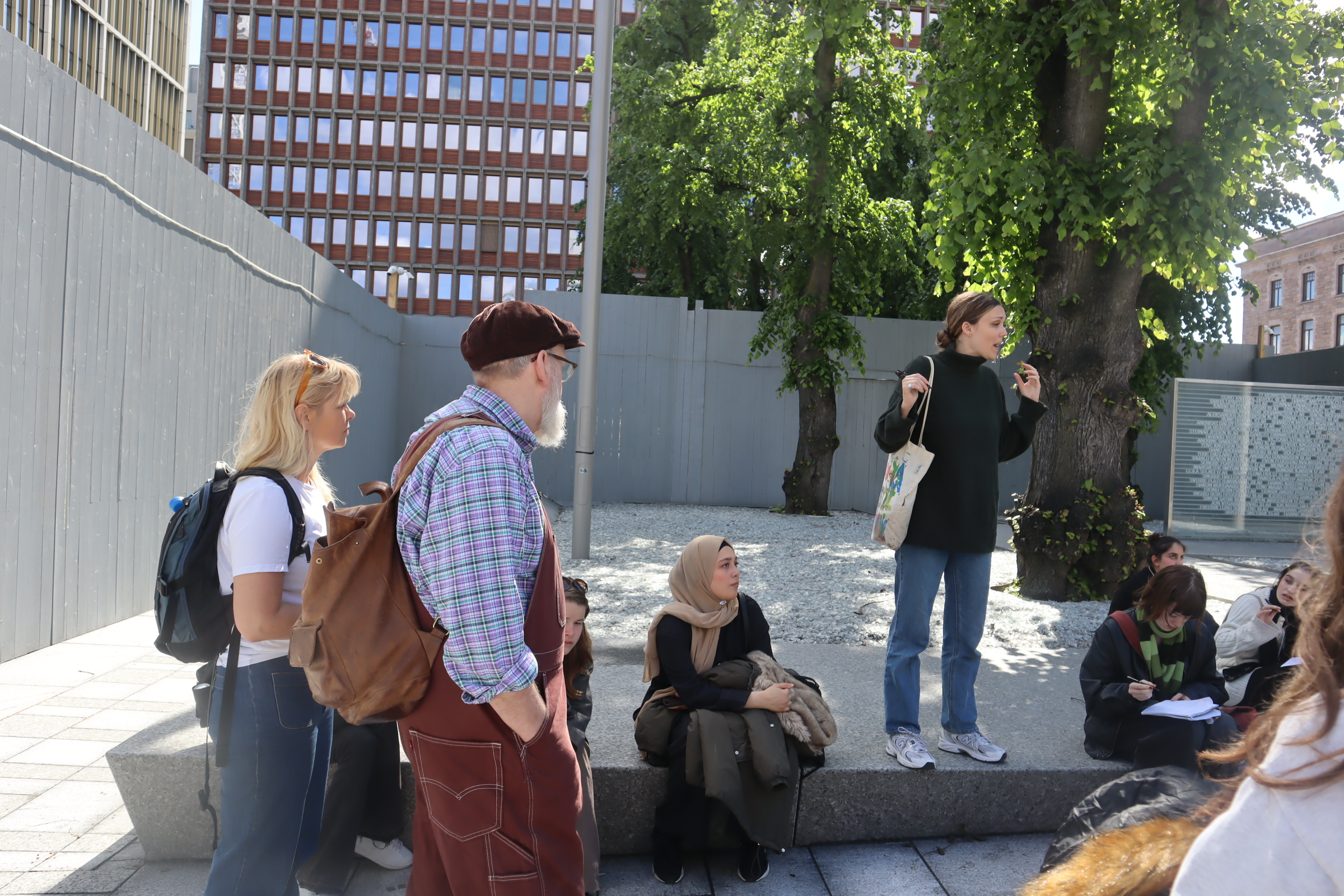 Lärare föreläser för elever utanför regeringsbyggnaden i Oslo.