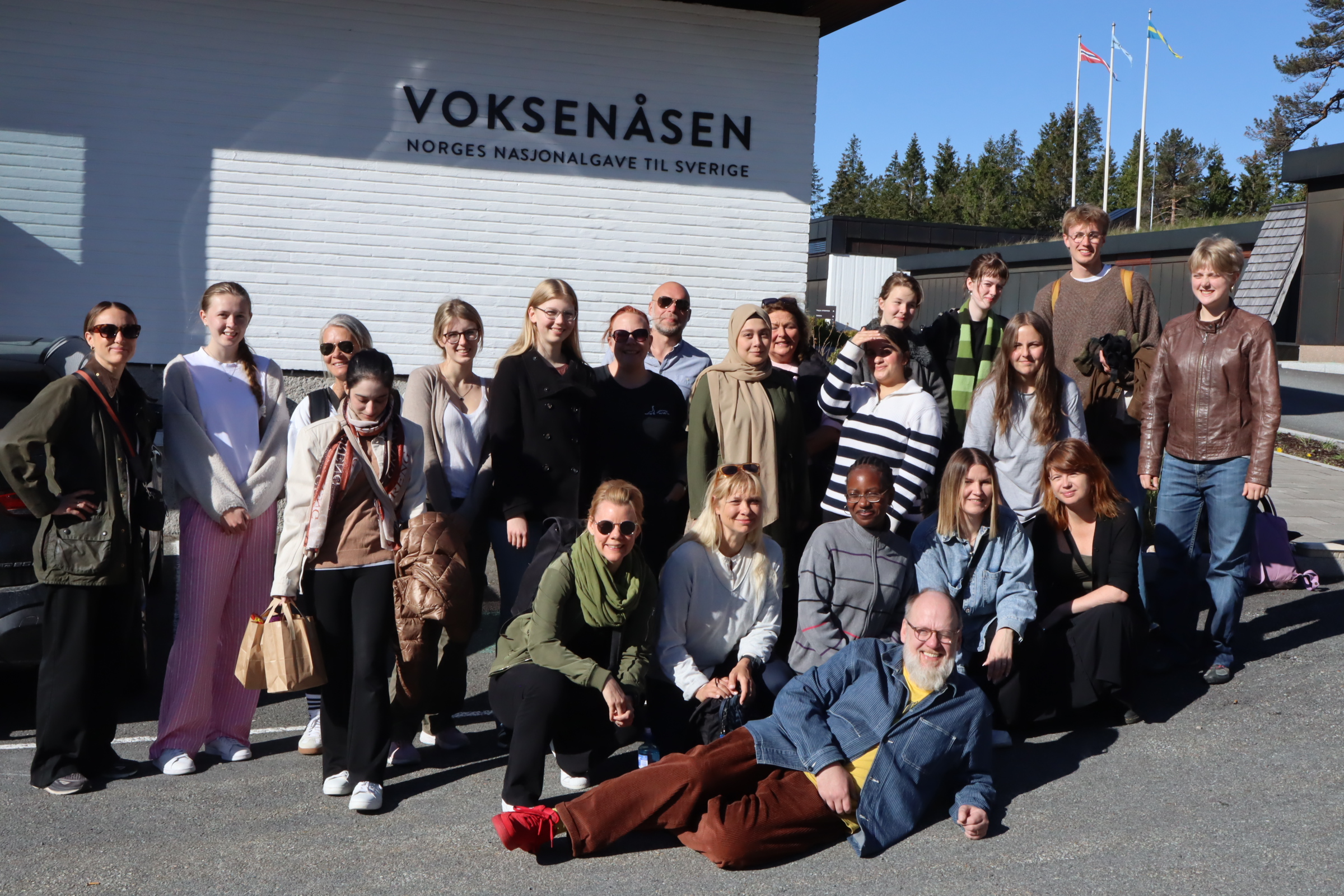 Elever och lärare står framför texten Voksenåsen.