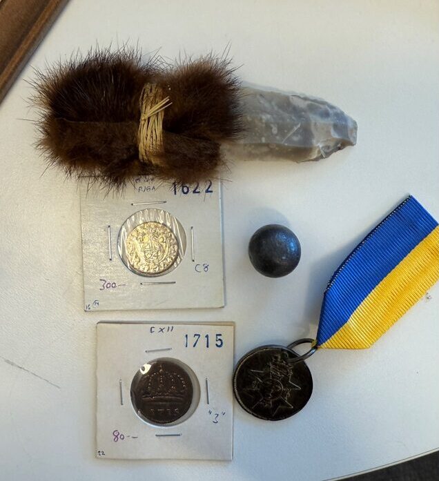 Mynt, kniv, kula och medalj.