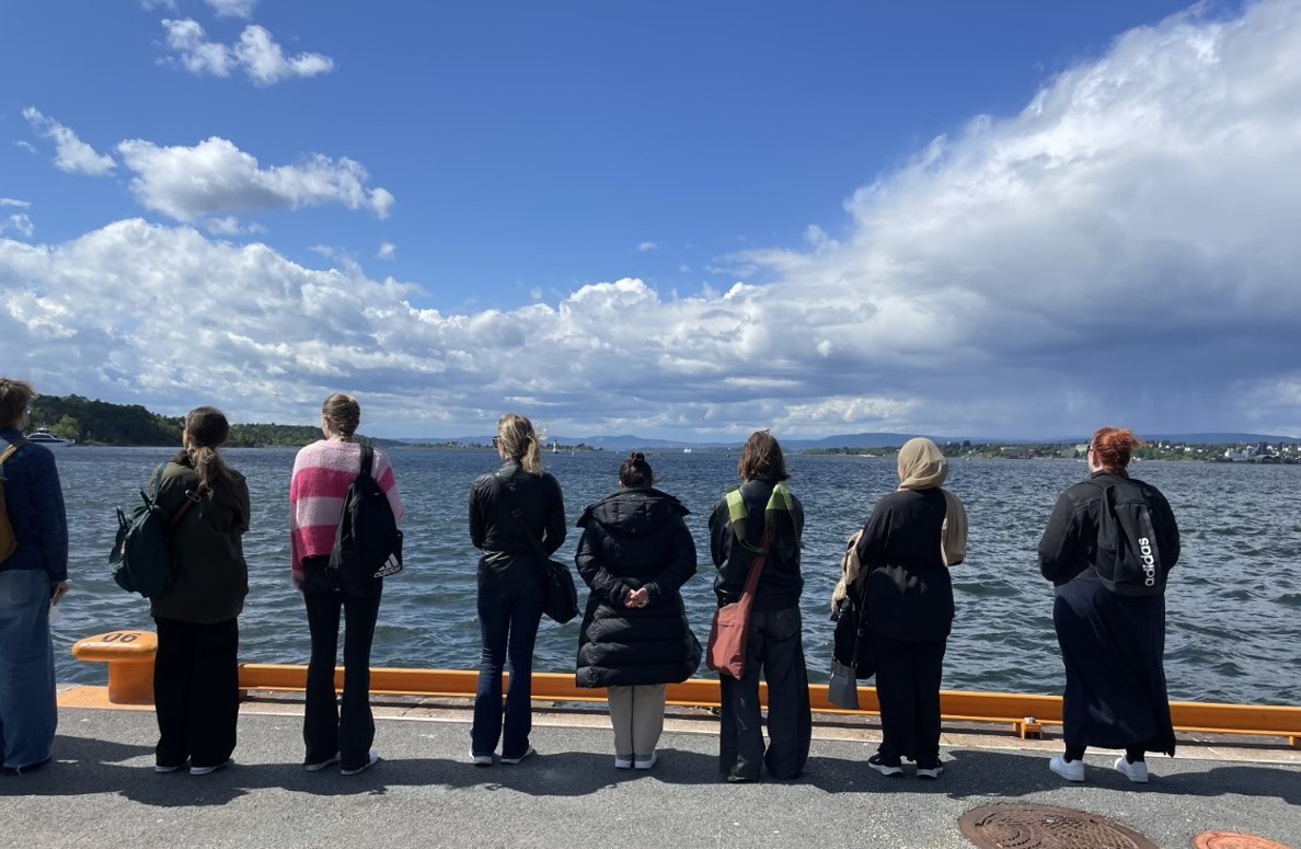 Elever står på en kaj och blickar ut mot vattnet.