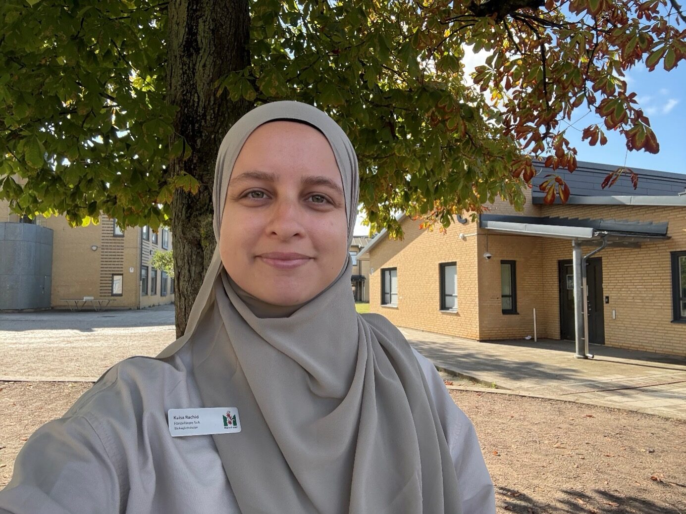 Kaisa Rachid tar en selfie under ett träd på skolgården.