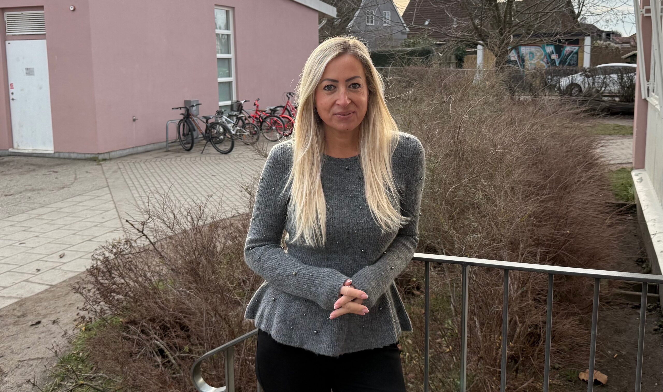 Lärare, kvinna står på skolgård.