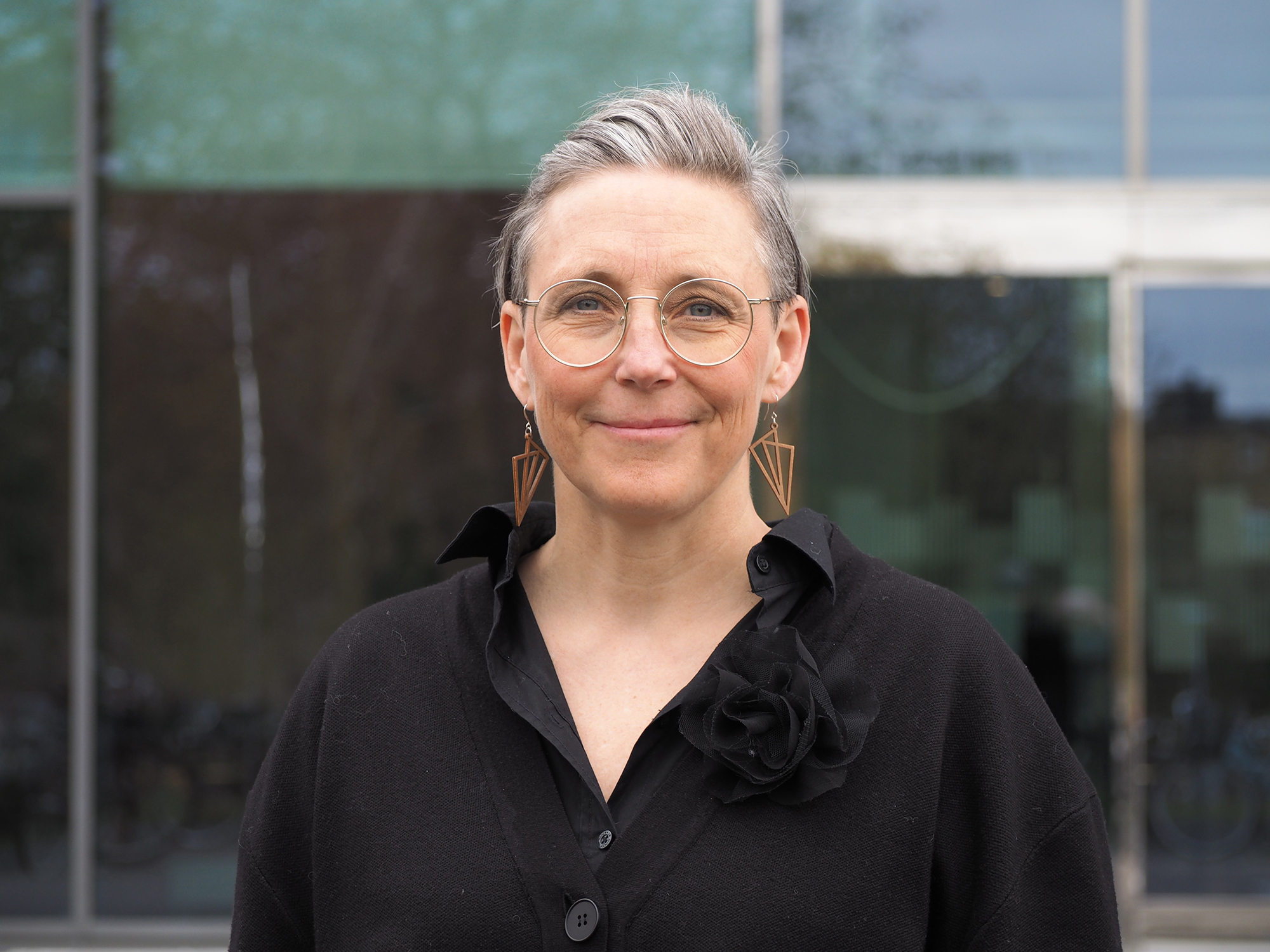 Porträtt av Annika Lexén framför en byggnad.