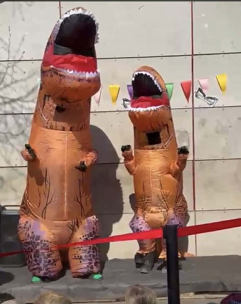 Två personer är utklädda till dinosaurier på skolgården och uppträder i 2masked singer".