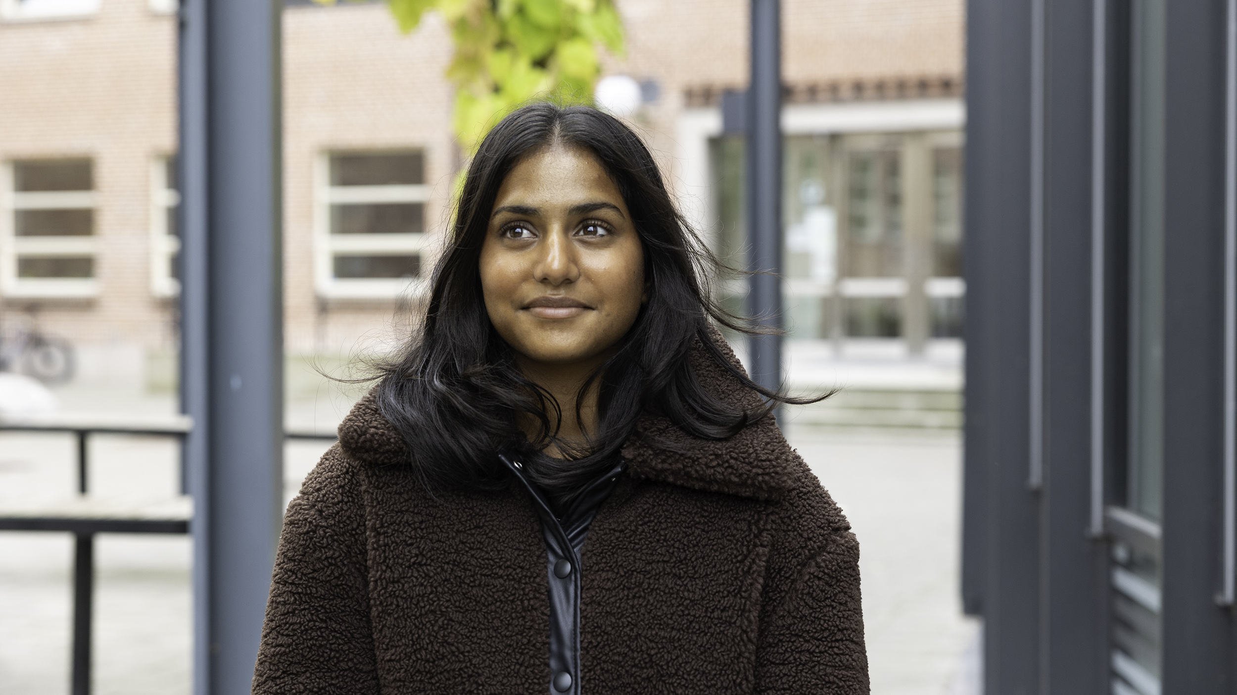 Elev står på skolgård och blickar uppåt.