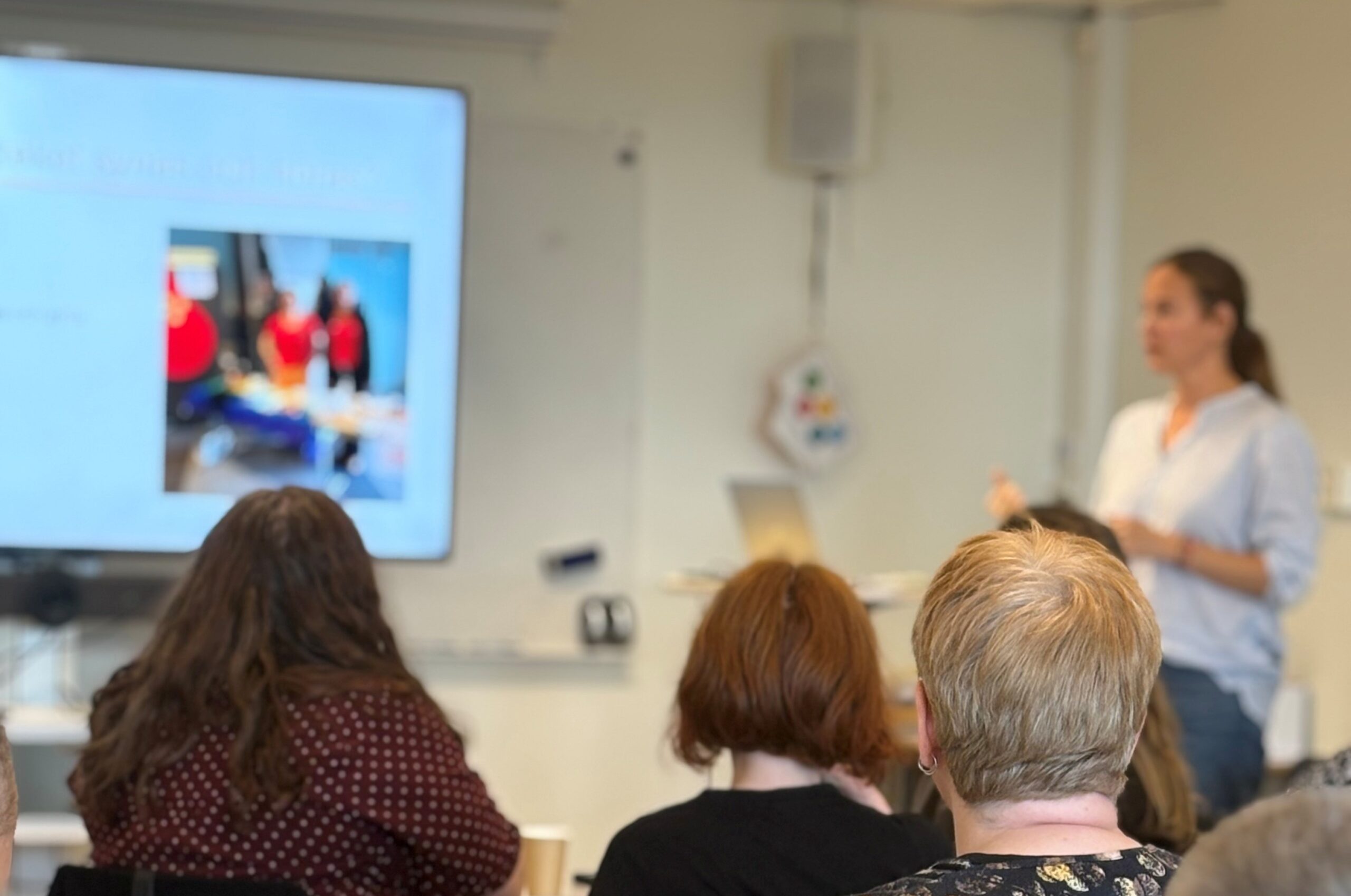 En person visar en presentation för några åhörare.